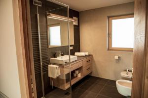 a bathroom with a sink and a glass shower at Kieserhof Apartment Alm in Terento +23 photos