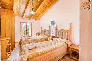 two beds in a room with wooden ceilings at Jaumet 2 Sant Martí de Barcedana in Aransís +16 photos