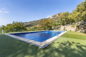 a swimming pool in a field with a mountain in the background at Jaumet 2 Sant Martí de Barcedana in Aransís