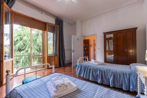 a bedroom with two beds and a large window at Cottage Casa Luisa in Montalcino +24 photos