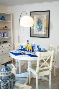 a white dining room with a white table and chairs at Royal Delft Boutique Apartment in Dinslaken +22 photos