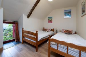two twin beds in a room with a window at Les gîtes Bretons in Bieuzy-les Eaux