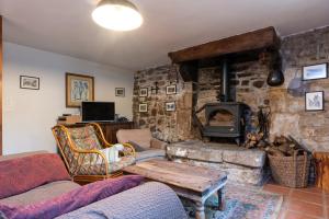 a living room with a stone wall with a fireplace at Les gîtes Bretons in Bieuzy-les Eaux