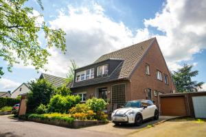 a small white car parked in front of a brick house at Royal Delft Boutique Apartment in Dinslaken