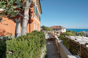 a walkway next to a building with the ocean in the background at Trilocale in villa Apt 5 in Varazze