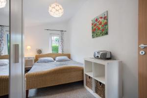 a bedroom with a bed and a table with a radio at Landhaus Peenemünde - Garten in Peenemünde