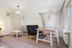 a living room with a table and a couch at Landhaus Peenemünde - Garten in Peenemünde