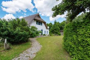 a white house with a stone path in front of it at Landhaus Peenemünde - Garten in Peenemünde