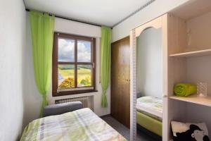 a bedroom with green curtains and a window at Ferienwohnung Christa in Lennestadt