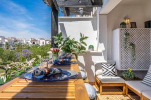 a wooden table with plates of food on a patio at Casa Albatros - Poolside Retreat in Torre-Pacheco