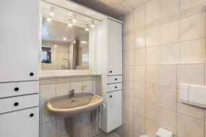 a bathroom with a sink and a mirror at Ferienwohnung Christa in Lennestadt +18 photos