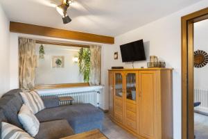 a living room with a couch and a tv at Ferienwohnung Christa in Lennestadt