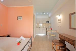 a living room with orange walls and a kitchen at Andromaches sea view studio in Corfu