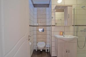 a bathroom with a toilet and a sink at Andromaches sea view studio in Corfu +12 photos