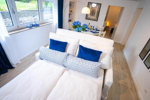 a living room with a white couch with blue pillows at Royal Delft Boutique Apartment in Dinslaken
