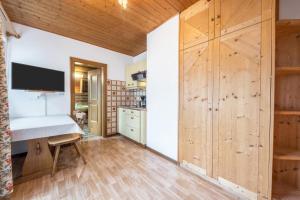 a kitchen with wooden cabinets and a desk in a room at Residence Kronstein - Fewo 7 in Tesimo