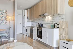 a kitchen with white appliances and a table in it at Backup-Powered Trendy City Balcony Apartment in Cape Town