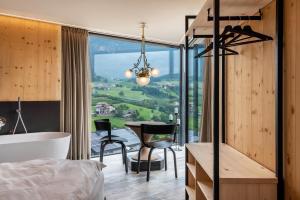 a bedroom with a bed and a desk and a tub at Aumia Apartment Diamant in Völs am Schlern