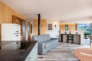 a living room with a couch and a kitchen at Aumia Apartment Diamant in Völs am Schlern