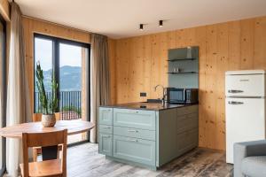 a kitchen with a refrigerator and a table and a window at Aumia Apartment Diamant in Völs am Schlern +17 photos