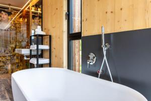 a bathroom with a white bath tub next to a window at Aumia Apartment Diamant in Völs am Schlern