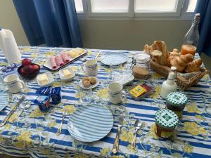 a blue and white table with plates and utensils at Chambre privative Dives Cabourg in Dives-sur-Mer