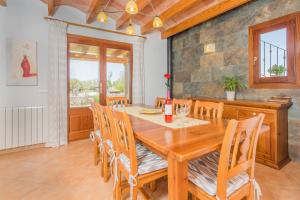 a dining room with a wooden table and chairs at Finca Can Cocou in Can Picafort