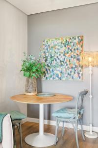 a dining room table with a vase of flowers on it at Backup-Powered Trendy City Balcony Apartment in Cape Town