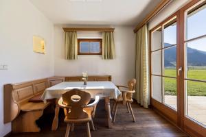 a dining room with a table and chairs and a window at Peintenhof Typ A in Sand in Taufers