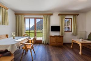 a dining room with a table and chairs and a television at Peintenhof Typ A in Sand in Taufers