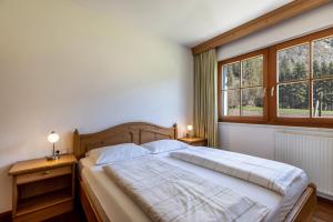a bedroom with a large bed with two windows at Peintenhof Typ A in Sand in Taufers