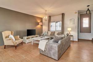 a living room with a couch and chairs and a tv at Almijarahouse in Nerja