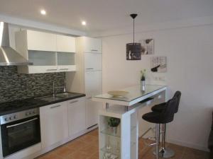 a kitchen with white cabinets and a counter top at Ferienwohnung am Sulzbach in Sulzburg