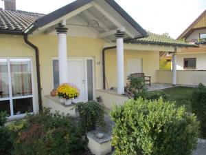 a house with two columns and a porch with flowers at Ferienwohnung am Sulzbach in Sulzburg