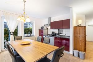 a kitchen and dining room with a wooden table and chairs at Fewo Zur Piste in Willingen
