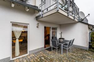 a patio with a table and chairs and a balcony at Fewo Zur Piste in Willingen