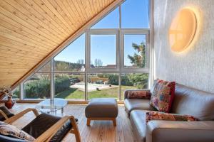 a living room with two couches and a large window at Ferienwohnung Waldidyll in Wolgast