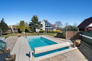 a swimming pool in the backyard of a house at Ferienwohnung Waldidyll in Wolgast