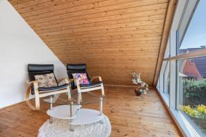 a room with two chairs and a glass table at Ferienwohnung Waldidyll in Wolgast