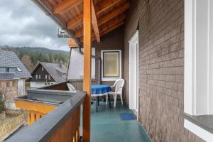 a balcony with a table and chairs on a house at Ferienhaus im Grund in Hinterzarten