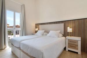 a white bedroom with a large bed and a window at Oasis Pool View in Maspalomas +16 photos