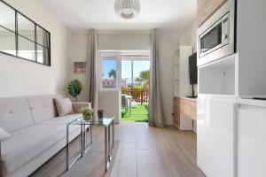 a living room with a couch and a table at Oasis Pool View in Maspalomas