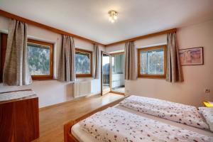 a bedroom with two beds and windows at Camping Passeier Arnika in Saltusio +17 photos