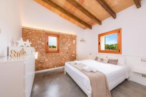 a bedroom with a large white bed and two windows at Sa Pleta in Manacor +29 photos