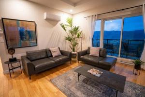 a living room with a couch and a table at 206 - Bright Modern Condo - Pool and River View in Baie-Saint-Paul