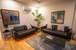 a living room with a leather couch and a table at 206 - Bright Modern Condo - Pool and River View in Baie-Saint-Paul +50 photos
