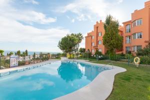 a swimming pool in a yard next to a building at Fuengirola Hills with Seaview in Fuengirola