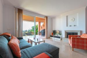 a living room with a blue couch and a fireplace at Fuengirola Hills with Seaview in Fuengirola