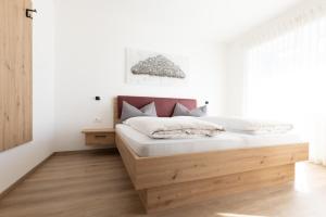 a bedroom with a bed with a wooden headboard at Kleon 2 in Rifiano