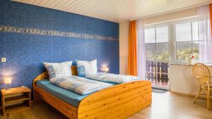 a bedroom with a wooden bed with a blue wall at Fewo Fuchs in Lauterbach